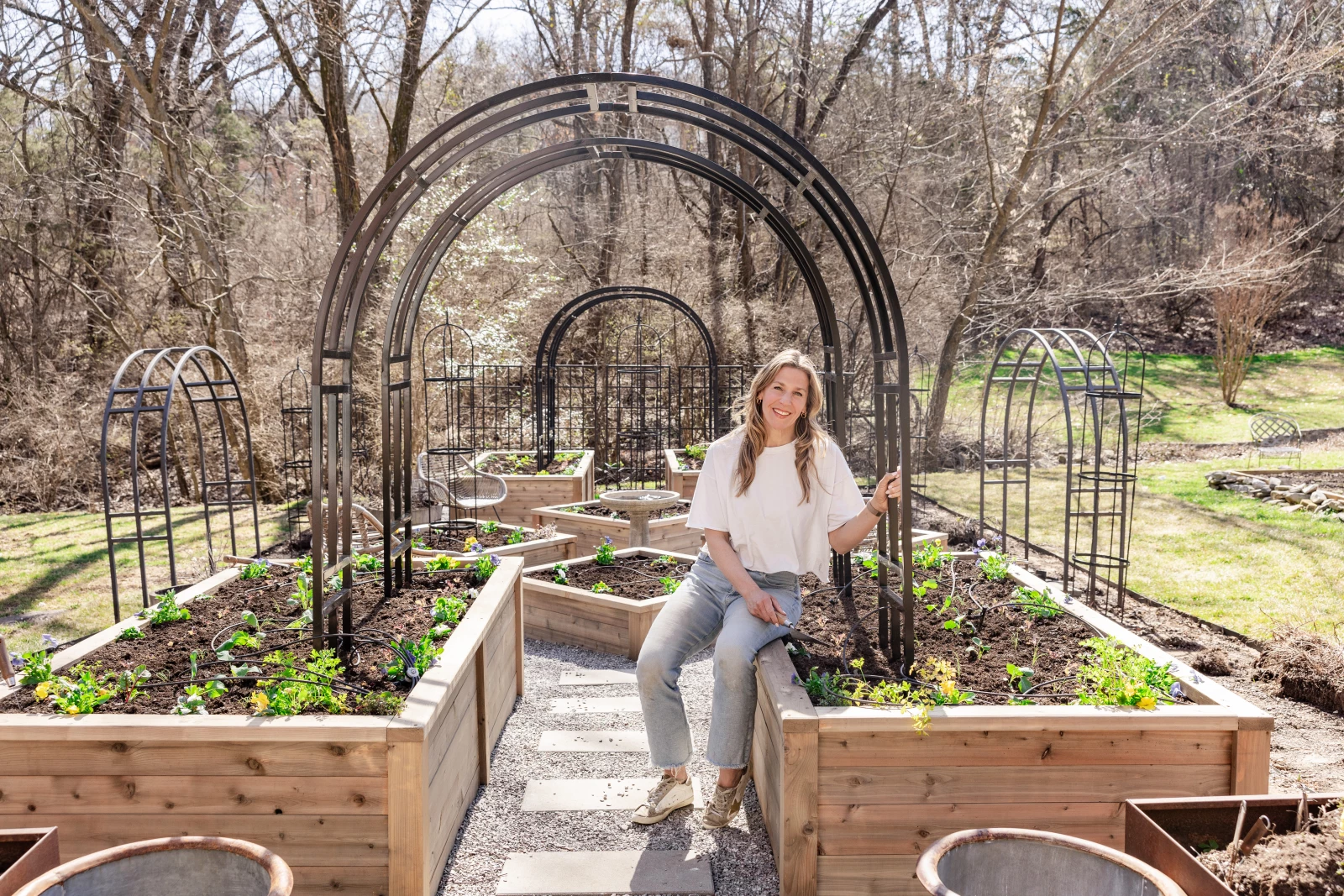 Nicole in her garden with an arch trellis